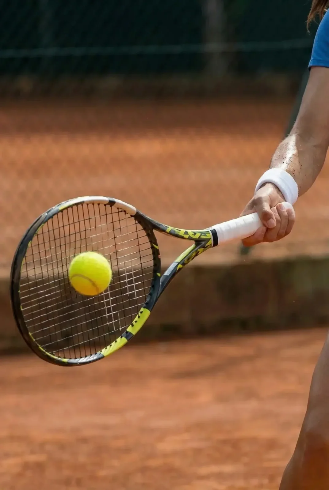Raqueta impactando la bola sobre tierra batida